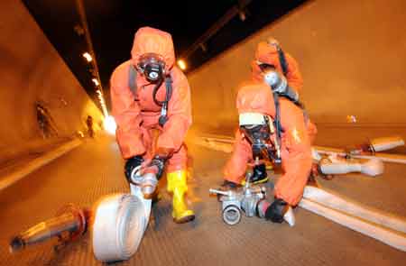 Firefighters take part in a fire drill at a tunnel on the highway linking Hefei and Mount Huangshan in east China's Anhui Province, Aug. 3, 2008. 