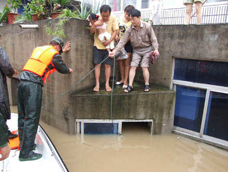 Armed police detachment rescue local residents surrounded by the flood water in Chuzhou City in central China's Anhui province on August 2, 2008. Caused by tropical storm Fung Wong, heavy rainfalls triggered floods in large areas of Chuzhou City on August 1 and August 2, demaging roads, bridges, river banks and power facilities.(Xinhua)