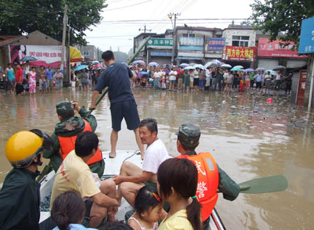 Armed police drive a boat to rescue local residents in flood water in Chuzhou City in central China's Anhui province on August 2, 2008. Caused by tropical storm Fung Wong, heavy rainfalls triggered floods in large areas of Chuzhou City on August 1 and August 2, demaging roads, bridges, river banks and power facilities.(Xinhua) 