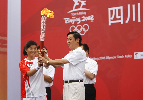 The first torchbearer Zhang Shan (L) receives the torch from Liu Qibao, secretary of Sichuan Provincial Committee of CPC on August 5, 2008.