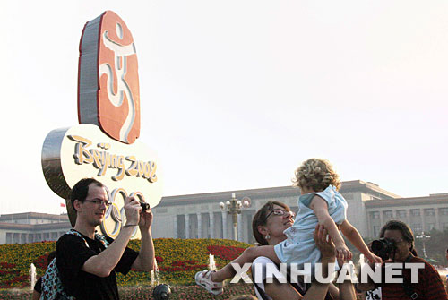 Foreigners take a photo in the front of the central flower terrace in Tian'anmen Square on August 3. 