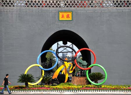A man passes by an Olympic-themed parterre beside the Drum Tower in Yinchuan, capital city of northwest China's Ningxia Hui Autonomous Region, Aug. 4, 2008. The whole city is immerged in an Olympic atmosphere with the approaching of the Beijing Olympics. (Xinhua/Wang Peng)