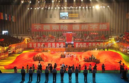 Performers show a large red cloth with two Chinese characters meaning 'feel grateful' during the Beijing 2008 Olympic Games torch relay around the track of Jiuzhou stadium in Mianyang City, the May 12 earthquake disaster zone in southwest China's Sichuan Province, Aug. 4, 2008. 