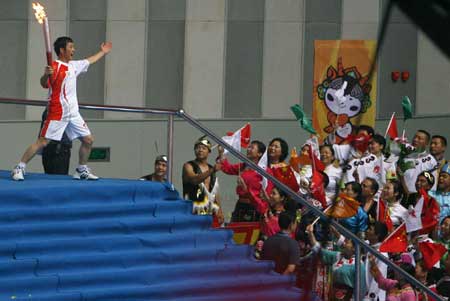  Torchbearer Zhao Chengcai poses with the torch during the Beijing 2008 Olympic Games torch relay around the track of Jiuzhou stadium in Mianyang City, the May 12 earthquake disaster zone in southwest China's Sichuan Province, Aug. 4, 2008. 
