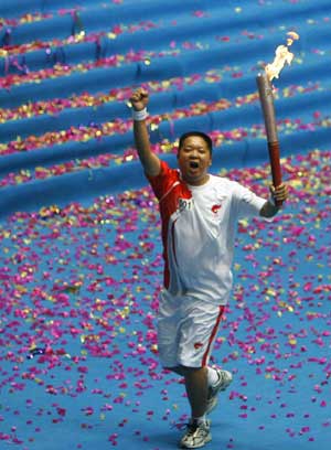 The first torchbearer Gou Yunzhang runs with the torch during the Beijing 2008 Olympic Games torch relay around the track of Jiuzhou stadium in Mianyang City, the May 12 earthquake disaster zone in southwest China's Sichuan Province, Aug. 4, 2008. 