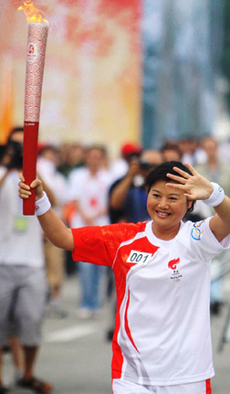 The first torchbearer Zhang Shan runs with the Olympic torch in Chengdu, Sichuan Province, August 5.