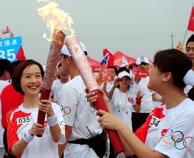 Torchbearers Guo Yu and Chen Luyu pass the Olympic flame in Chengdu, Sichuan Province, on August 5. 