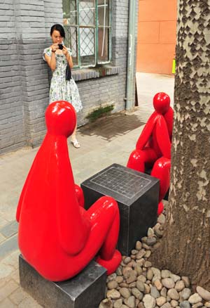 A visitor takes photos of sculptures at 798 Art Zone in Beijing, capital of China, Aug. 5, 2008. 
