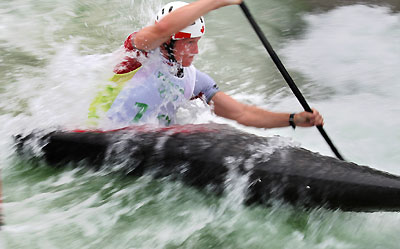 Padding hard, a canadian canoeist fights to break the block of the rapids. [Xinhua]