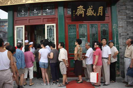Customers queue up at a time-honored shop on the newly-renovated Qianmen Street in central Beijing, China, Aug. 7, 2008. [Jin Liangkuai/Xinhua]