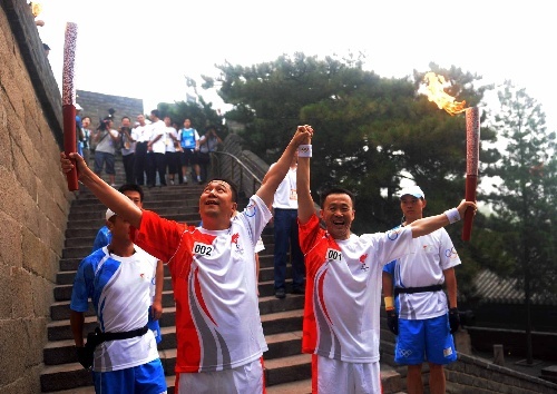 Li Zhonghua and the second torchbearer cheer after the flame is pased in Beijing August 7. 