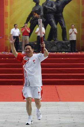 Torchbearer Wang Haiping runs with Olympic torch in Beijing August 7. 