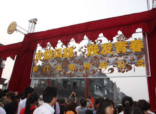 Visitors crowd in front of the stage set for the opening ceremony of the historical Qianmen Street, August 7, 2008. Qianmen Street reopens to the public Thursday after almost a year's renovation. [Photo: CRIENGLISH.com] 