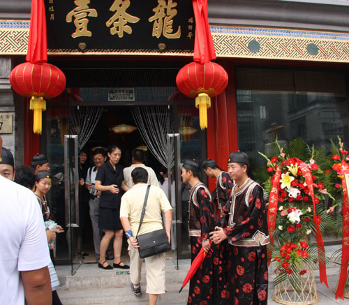 Waiters dressed in the traditional costumes of the Qing Dynasty greet guests at the entrance to the Yitiaolong restaurant, August 7, 2008. [Photo: CRIENGLISH.com] 