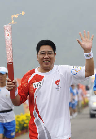 Torchbearer Gao Dianmin runs with the torch during the Beijing 2008 Olympic Games torch relay in Beijing, China, Aug. 7, 2008. (Xinhua/Qi Heng)