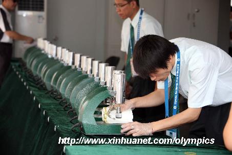 Staffs check stampers during Olympic Expo Beijing 2008 in Beijing Exhibition Center in Beijing, capital of China, on the opening day of Aug. 8, 2008. [Zhang Yanhui/Xinhua]