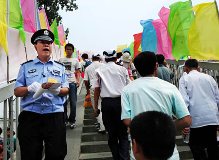 A policeman guides tourists and citizens to get on the overbridge near the National Stadium, known as the Bird's Nest, in Beijing, China, at about 3:00 p.m. on Aug. 8, 2008, 5-hour countdown to the opening ceremony of the Olympics. The opening ceremony of the Beijing 2008 Olympic Games will be held in the National Stadium at 8:00 p.m. on Aug. 8. (Xinhua/Li Ziheng) 