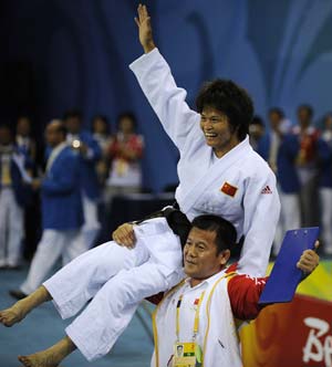 Xian Dongmei of China is lifted by her coach after she defeats An Kum Ae of the Democratic People’s Republic of Korea during the women -52 kg final of judo at the Beijing Olympics in Beijing, China, Aug. 10, 2008. Xian Dongmei gained the gold medal of the event.