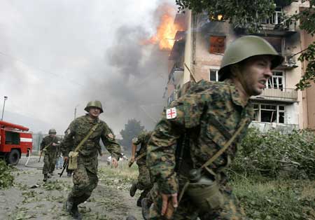 Soldiers run near a blazing apartment after a bombardment in the town of Gori, 80 km (50 miles) from Tbilisi, Aug. 9, 2008. 