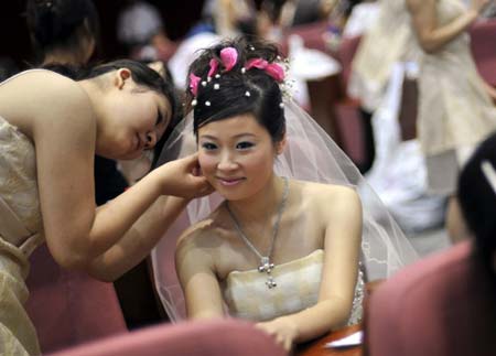 Chinese brides prepare for a mass wedding ceremony in Wuhan, central China's Hubei province on 08 August 2008. 
