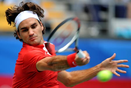 Roger Federer of Switzerland returns a hit against Dmitry Tursunov of Russia in the first round of the men&apos;s singles of the Olympic tennis competition in Beijing, China, Aug. 11, 2008. Federer beat Tursunov 2-0. (Xinhua/Wang Yuguo)