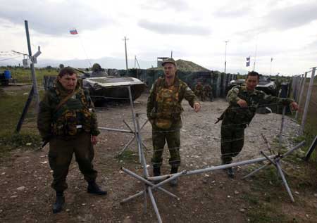 Russian peacekeepers stand at the checkpoint near the town of Tskhinvali, some 100 km (62 miles) from Tbilisi, Aug. 10, 2008. Russian warships arrived at Georgia's Black Sea coast on Sunday following three days of fighting in the breakaway Georgian region of South Osettia, Russian media reported. 