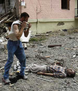 A Georgian man pulls off his T-shirt as he stands near the body of his relative after a bombardment in Gori, 80 km (50 miles) from Tbilisi, Aug. 9, 2008. (Xinhua/Reuters Photo)