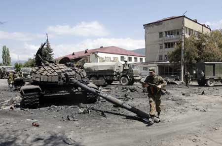 A Russian soldier walks past destroyed Georgian tanks in the South Ossetian capital of Tshinvali, Aug. 10, 2008. Russian troops took most of the capital of the separatist Georgian region of South Ossetia on Sunday after a three-day battle but the United States condemned Moscow's 'dangerous and disproportionate' action. (Xinhua/Reuters Photo)