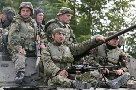 Georgian soldiers sit on a tank moving near the town of Tskhinvali, some 100 km (62 miles) from Tbilisi, Aug. 10, 2008. Georgia has withdrawn its forces from breakaway South Ossetia, where they had been fighting Russian troops for control, the Georgian interior ministry said on Sunday. But the Russian army said Georgian forces were still there. (Xinhua/Reuters Photo)