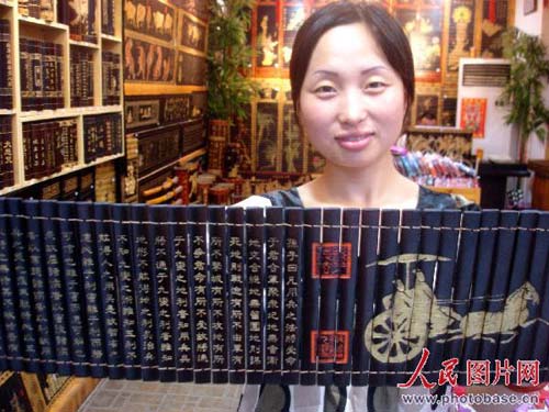 A customer shows her newly purchased bamboo slips in a handcraft shop in Shantang street in Suzhou, Jiangsu Province on August, 9, 2008. [Photo: photobase.cn]