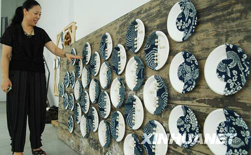 Xu Lingzhi exhibits her artwork made by old china plates in Truecolor Museum in Suzhou on Sunday, August 10, 2008. [Xinhua] 