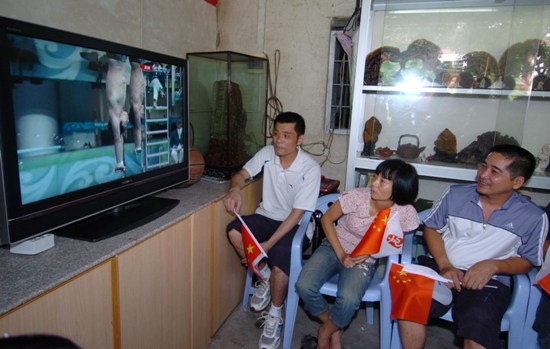 Lin Yue&apos;s parents (R1, R2) watching their son on TV at home in Chao Zhou, Guangdong Province.