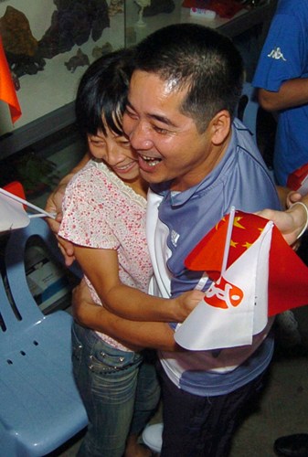 Lin Yue&apos;s parents hug each other at their son&apos;s top performance in the 10m synchro men.