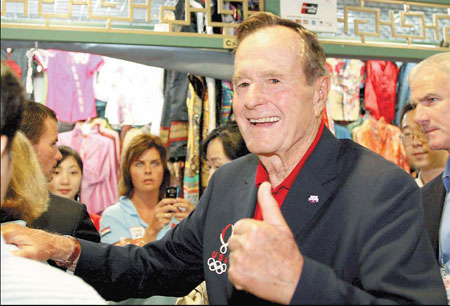 Former President George H. W. Bush gives the thumbs yesterday during a shopping trip to the Silk Market. [China Daily]