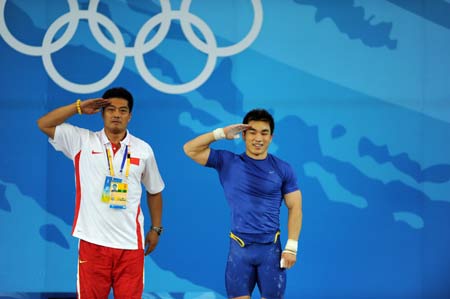  Liao Hui (R) of China and his coach salute to spectators after winning the men's 69kg final of weightlifting at Beijing 2008 Olympic Games in Beijing, China, Aug. 12, 2008. Liao won the gold medal with a total of 348 kilos. 