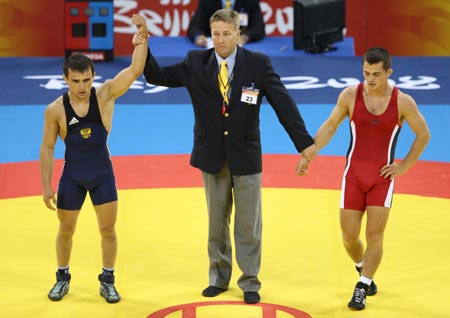 Nazyr Mankiev (L) of Russia is announced as winner after defeating Rovshan Bayramov (R) of Azerbaijan at the men's Greco-Roman 55kg gold medal match at the Beijing 2008 Olympic Games in Beijing, China, Aug. 12, 2008. Nazyr Mankiev won the bout and grabbed the gold medal of the event. 