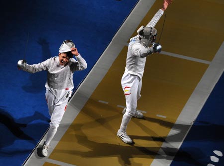 Zhong Man (L) of China celebrates his victory over Jaime Marti of Spain during their match at the men's individual sabre round of 16 of the Beijing 2008 Olympic Games fencing event at the Fencing Hall of National Convention Center in Beijing, Aug 12, 2008.[Xinhua] 