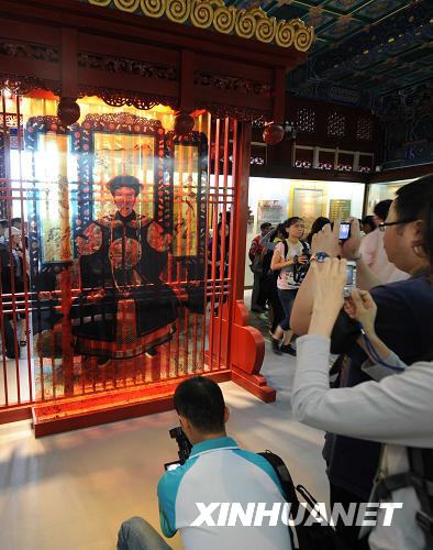 Journalists take photos of a portrait of He Shen inside his former residence, the Prince Gong&apos;s Mansion, in central Beijing on August 11, 2008. [Xinhuanet]