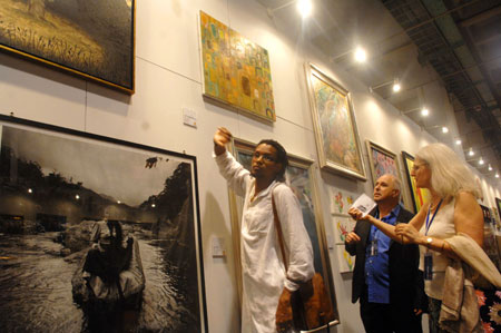 Visitors view artworks displayed at the China International Exhibition Center in Beijing, capital of China, Aug. 11, 2008. The Olympic Fine Arts 2008, held by the International Olympic Committee (IOC), opened in Beijing Monday, displaying more than 800 works selected from about 10,000 works of more than 40 countries and regions.[Xinhua]