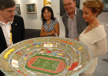 Visitors view an artwork displayed at the China International Exhibition Center in Beijing, capital of China, Aug. 11, 2008. The Olympic Fine Arts 2008, held by the International Olympic Committee (IOC), opened in Beijing Monday, displaying more than 800 works selected from about 10,000 works of more than 40 countries and regions. [Xinhua]