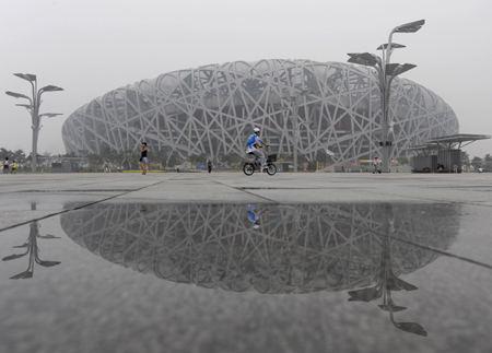 The National Stadium, also known as the Bird's Nest, is seen reflected after rainfall in Beijing, August 10, 2008. [Agencies]