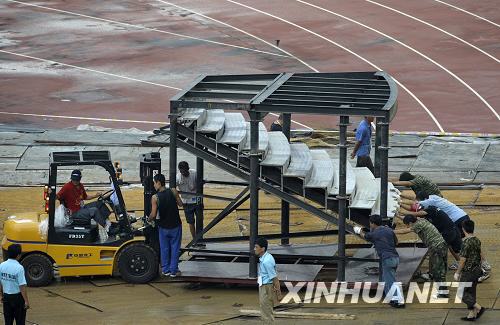Workers move a stand used during the opening ceremony of the Olympics in the National Stadium on August 10, 2008. [Photo: Xinhuanet]
