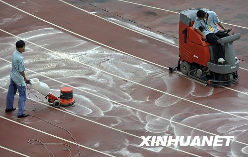 Workers clean the tracks in the National Stadium to prepare for upcoming matches on August 10, 2008. [Photo: Xinhuanet]