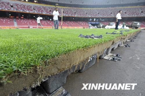 Workers pave the lawn in the National Stadium to prepare for upcoming matches on August 10, 2008. [Photo: Xinhuanet]