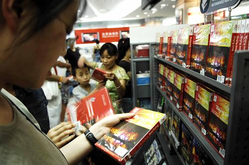 A customer checks out a DVD copy of the opening ceremony of the Beijing Olympics at the Beijing Book Building on August 11, 2008. The DVDs went on the market on the same day. [Photo: Xinhua]