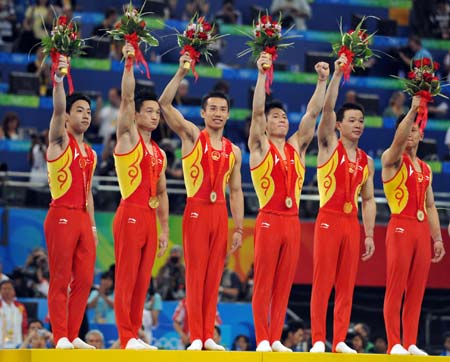 China&apos;s Zou Kai, Yang Wei, Xiao Qin, Li Xiaopeng, Huang Xu and Chen Yibing (L-R) wave to spectators on the podium during the awarding ceremony for gymnastics artistic men&apos;s team competition of the Beijing 2008 Olympic Games at National Indoor Stadium in Beijing, China, Aug. 12, 2008. The Chinese team won the gold medal of the event with 286.125 points. (Xinhua/Wang Lei)
