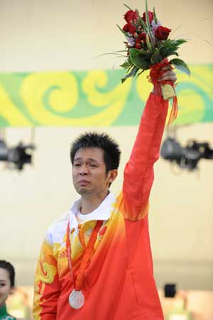 Zhu Qinan of China waves to spectators on podium during awarding ceremony of men's 10m air rifle final of Beijing Olympic Games at Beijing Shooting Range Hall in Beijing, China, Aug. 11, 2008. Zhu took the silver medal of the event with 699.7 points. [Jiao Weiping/Xinhua]