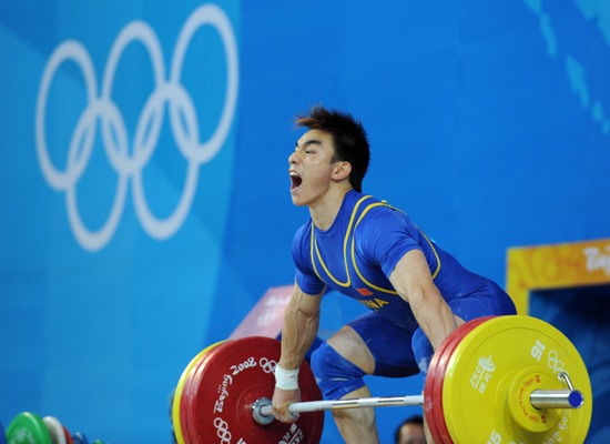 Liao Hui of China celebrates after taking a successful lift during the men's 69kg final of weightlifting at Beijing 2008 Olympic Games in Beijing, China, Aug. 12, 2008. Liao won the gold medal with a total of 348 kilos. [Xinhua]