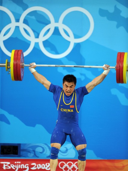 Liao Hui of China celebrates after taking a successful lift during the men's 69kg final of weightlifting at Beijing 2008 Olympic Games in Beijing, China, Aug. 12, 2008. Liao won the gold medal with a total of 348 kilos. [Xinhua]