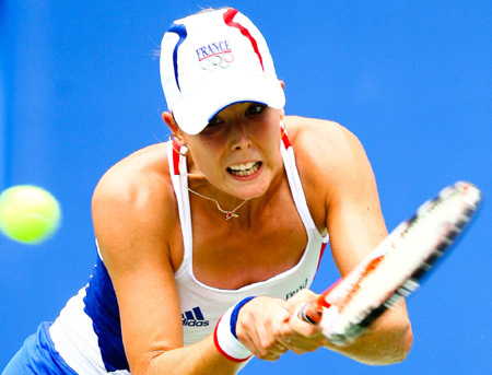 Alize Cornet of France hits a return against Peng Shuai of China at the second round of women's singles during the Beijing Olympic Games tennis event in Beijing, China, Aug. 12, 2008. Alize Cornet won the match 2-0. [Xinhua]